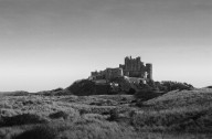 Bamburgh Castle behind grass covered sand dunes